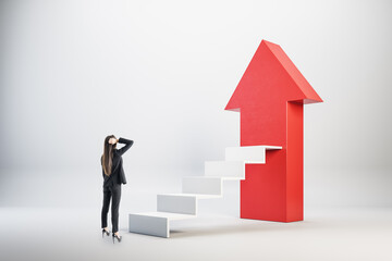 Businesswoman looking on stairs with large red arrow