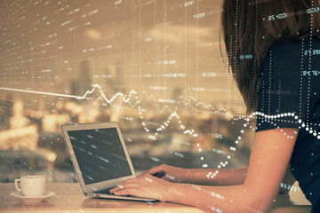 Double exposure of businesswoman hands typing on computer and forex chart hologram drawing. Financial analysis concept.