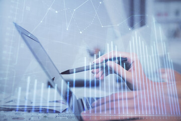 Multi exposure of woman hands typing on computer and financial graph hologram drawing. Stock market analysis concept.