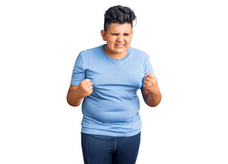 Little boy kid wearing sports workout clothes very happy and excited doing winner gesture with arms...