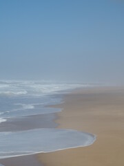 The shoreline in the beach with the fog in the background.