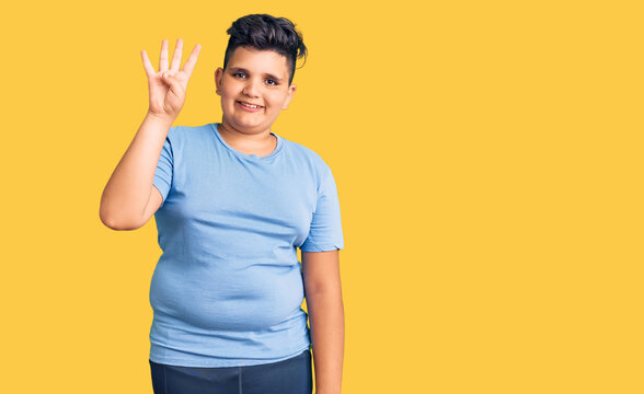 Little boy kid wearing sports workout clothes showing and pointing up with fingers number four while smiling confident and happy.