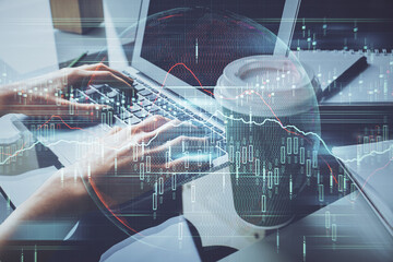 Double exposure of woman hands typing on computer and forex chart hologram drawing. Stock market...