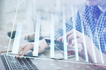 Double exposure of man hands holding a credit card and Forex graph drawing. Stock trading and digital fintech in Internet E-commerce concept.