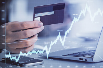 Multi exposure of woman on-line shopping holding a credit card and financial graph drawing. Stock market E-commerce concept.