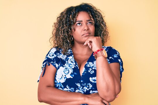 Young african american plus size woman wearing casual clothes thinking concentrated about doubt with finger on chin and looking up wondering