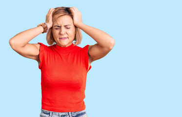 Young blonde woman wearing casual clothes suffering from headache desperate and stressed because pain and migraine. hands on head.