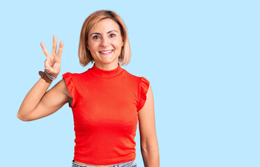 Fototapeta premium Young blonde woman wearing casual clothes showing and pointing up with fingers number three while smiling confident and happy.