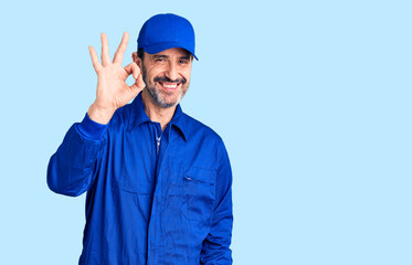 Middle age handsome man wearing mechanic uniform smiling positive doing ok sign with hand and fingers. successful expression.