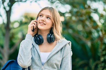 Beautiful caucasian student teenager smiling happy talking on the smartphone at the park