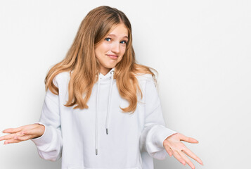 Beautiful young caucasian girl wearing casual sweatshirt clueless and confused expression with arms...