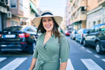 Young hispanic woman on vacation smiling happy walking at street of city