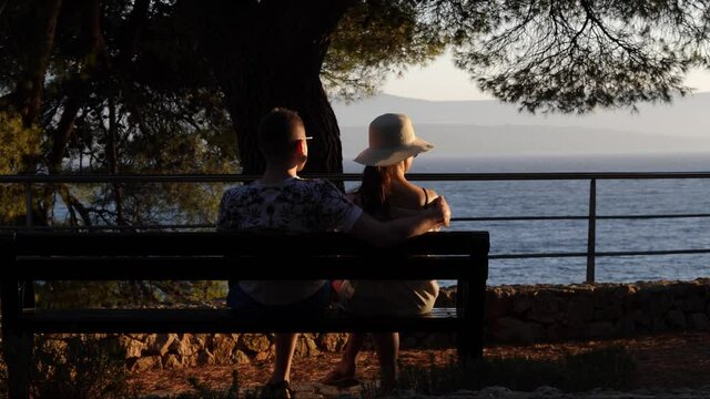 Couple sitting on a bench at sunset, Bol, Croatia