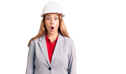 Beautiful young woman wearing architect hardhat afraid and shocked with surprise expression, fear and excited face.