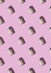 pattern with a jar of vitamins on a pink background

