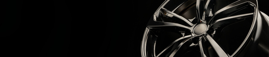 black stylish rim alloy wheel on a dark background. close-up, layout for the design of car sites,...
