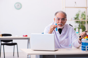 Old male chemist working in the lab
