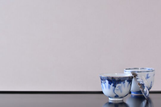 picture rice bowl. with picture cup. put on a Japanese lacquer shelf. This is a very fine example of Japanese traditional antique &ldquo; imari ware &rdquo;. blurred background soft focus image.