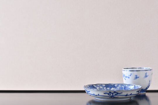 picture plate.  with picture cup. put on a Japanese lacquer shelf. This is a very fine example of Japanese traditional antique &ldquo; imari ware &rdquo;. blurred background soft focus image.