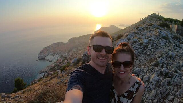 Sunset selfie of a couple on Mount Srd over Dubrovnik city, Croatia