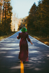 Young woman walking down road in autumn 