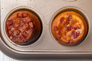 Egg bites for breakfast with pieces of bacon in a metal form. Isolate