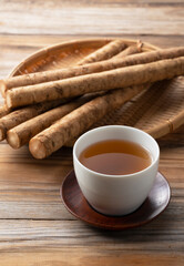 Burdock tea on a wooden board in the background