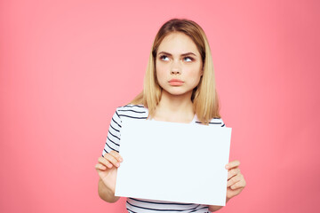 Naklejka premium woman holding white sheet in her hands striped t-shirt emotions pink background
