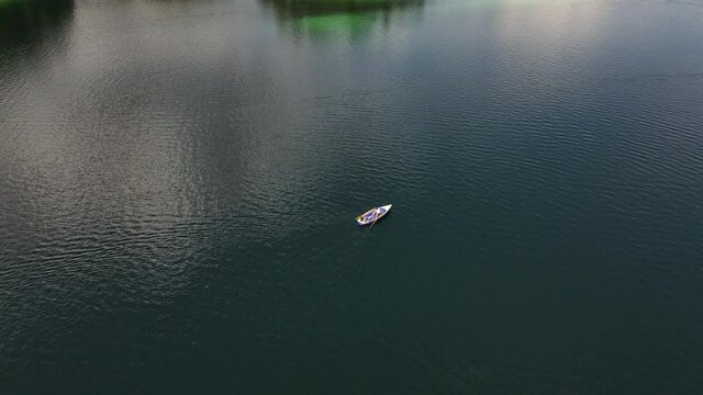 Drone circling around a rowboat on a beautiful lake, landscape, cute couple, love, lovers,  relax, nature, dinghy, tourism, vacation, holiday, aerial drone shot