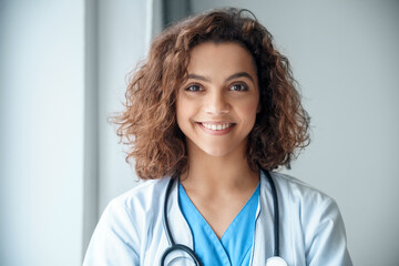 Close-up portrait of young female doctor wear smiling and looking at camera.