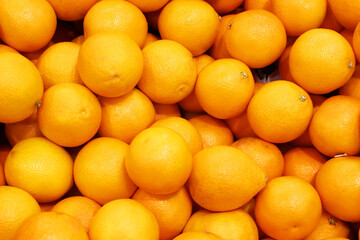 Lemon, orange, fresh fruit mix as background, top view. fresh citrus fruit market. A pile of oranges sitting on top of a wooden table 