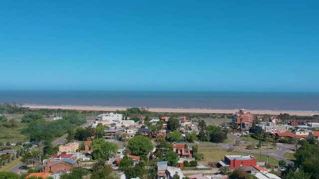 Drone moving over the building along the coastline beach
