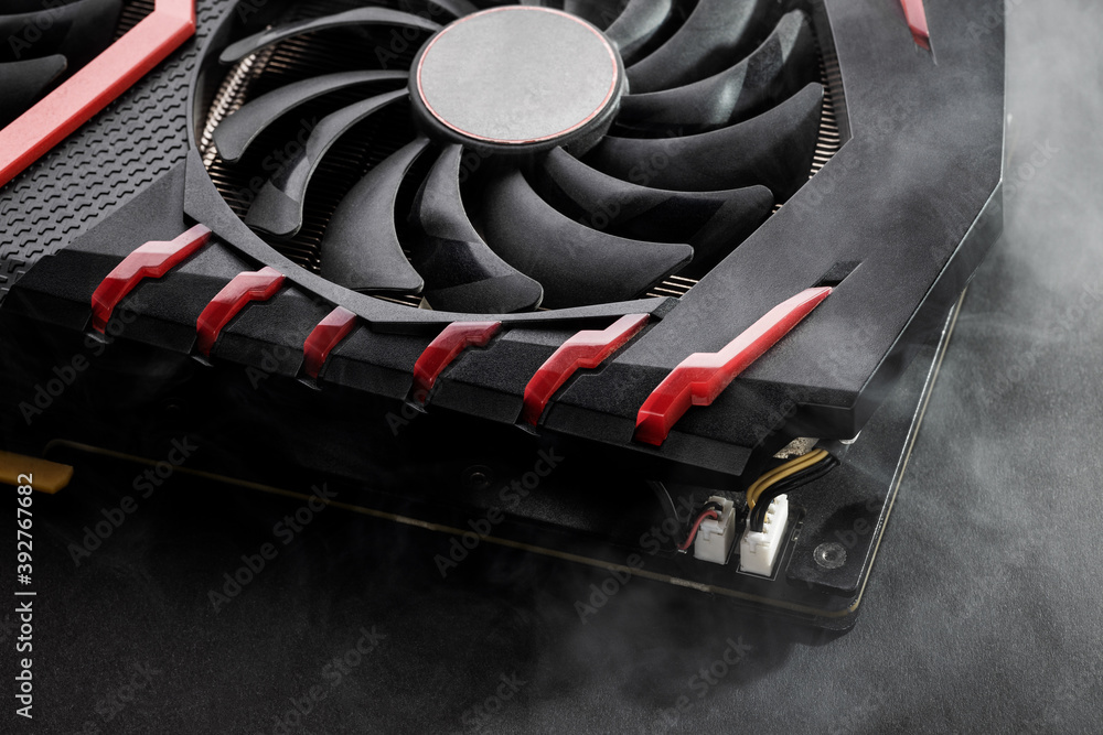 Poster close up broken graphics card with smoke on foreground and dark background. overheating gpu hardware