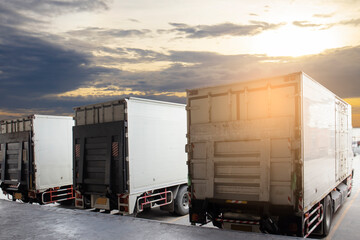 Fototapeta na wymiar Cargo container truck parking at sunset sky at the warehouse. Road freight cargo shipment. Logistics and transportation.