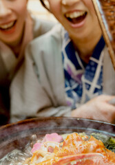 鍋の蓋を開ける浴衣姿の女性