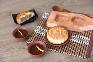 Moon cakes and wooden moon cake molds for the Mid-Autumn Festival and two cups of tea