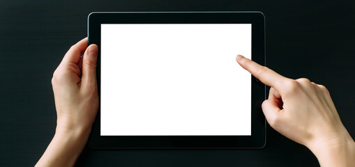 Tablet computer with white blank screen in hands isolated on black background. Holding and pointing to empty screen on digital tablet. Copy space.
