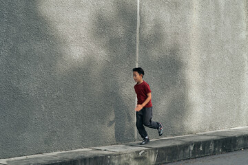 Young asian boy running and work out in outdoor. Active kids. Self care and health care concept.