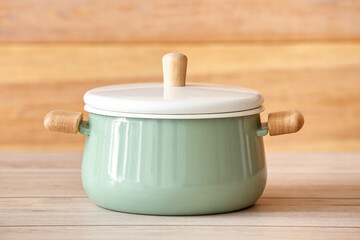 Cooking pot on table against wooden background