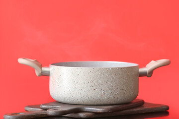 Cooking pot on table against color background