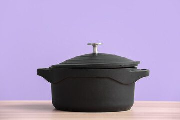 Cooking pot on table against color background