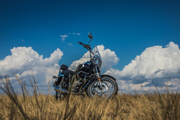motorcycle on a background of clouds and yellowed grass