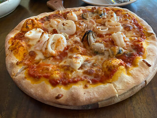 Freshly baked seafood pizza with shrimps, squid and mussels