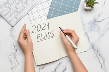 Woman making to do list on 2021 year, top view
