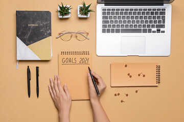Woman making to do list on 2021 year, top view