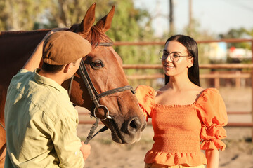 Obraz premium Young couple with cute horse outdoors