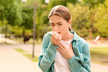 Young woman suffering from allergy outdoors