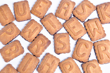 A variety of cookie letters are scattered all over the frame on a white clipping background