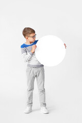 Little boy with blank paper sheet on light background