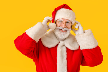 Cool Santa Claus listening to music on color background